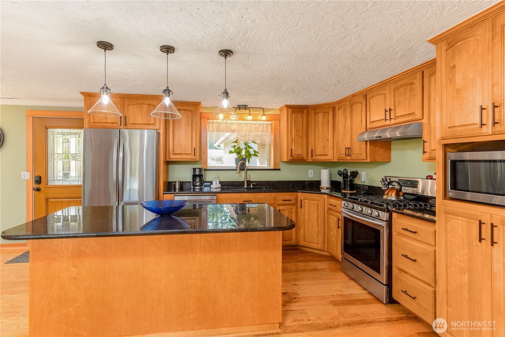 273702 Highway 101 Sequim, WA 98382 - Photo 9 of 40 a kitchen with stainless steel appliances granite countertop a stove a sink and a refrigerator