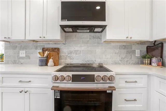 a spacious bathroom with a granite countertop sink a mirror a bathtub and shower