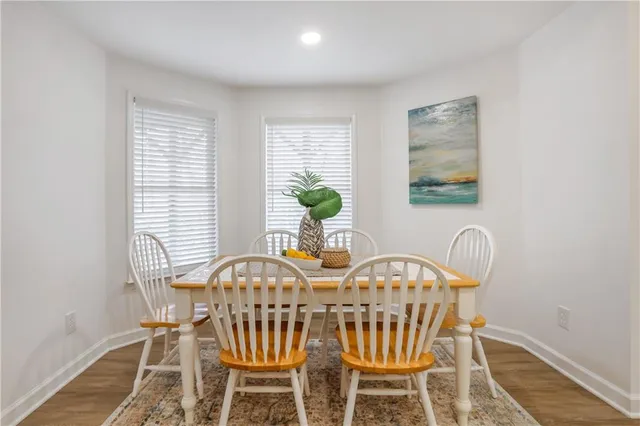 a view of a white house with large windows next to a road
