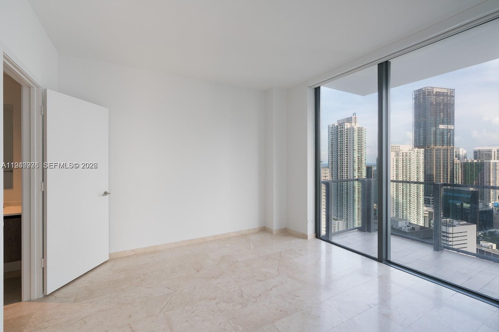 68 Southeast 6th Street, Unit 3402 Miami, FL 33131 - Photo 11 of 22 a view of an empty room with glass door