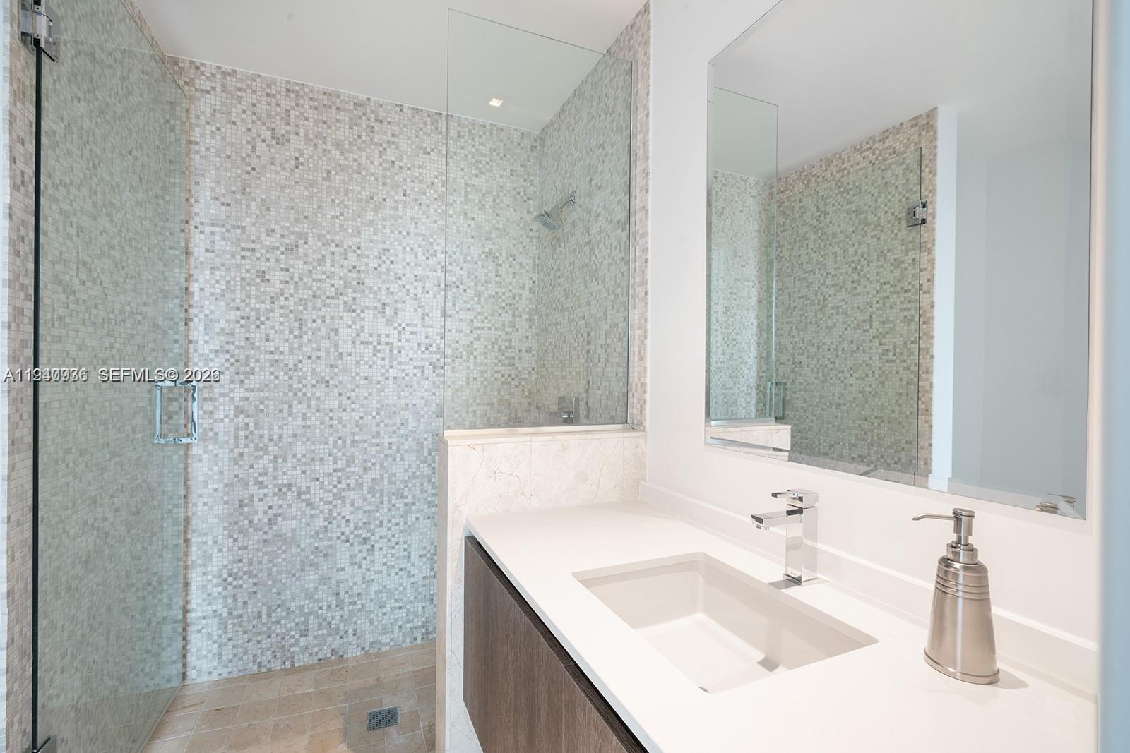 68 Southeast 6th Street, Unit 3402 Miami, FL 33131 - Photo 12 of 22 a bathroom with a sink and a mirror