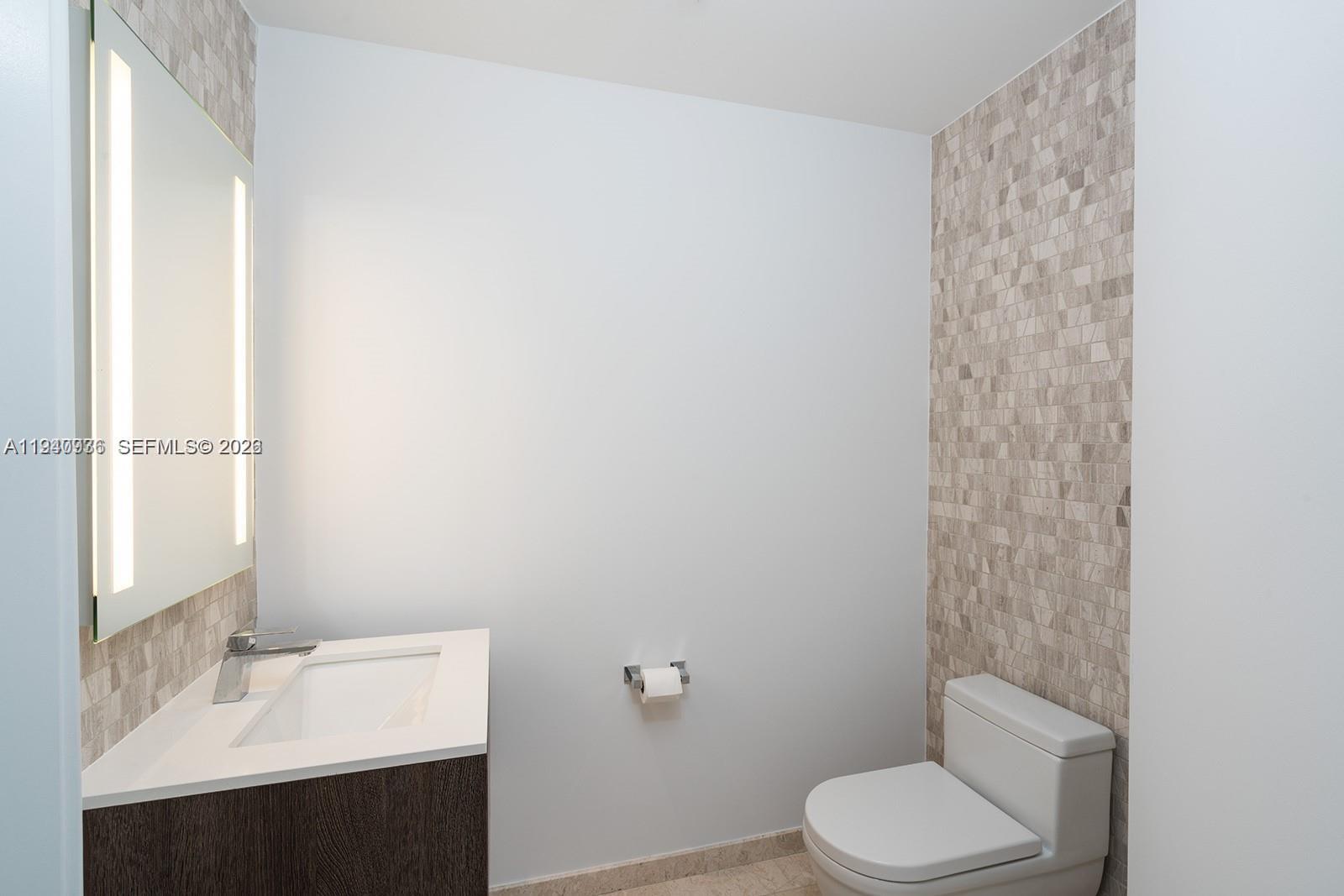 68 Southeast 6th Street, Unit 3402 Miami, FL 33131 - Photo 13 of 22 a bathroom with a sink toilet and vanity