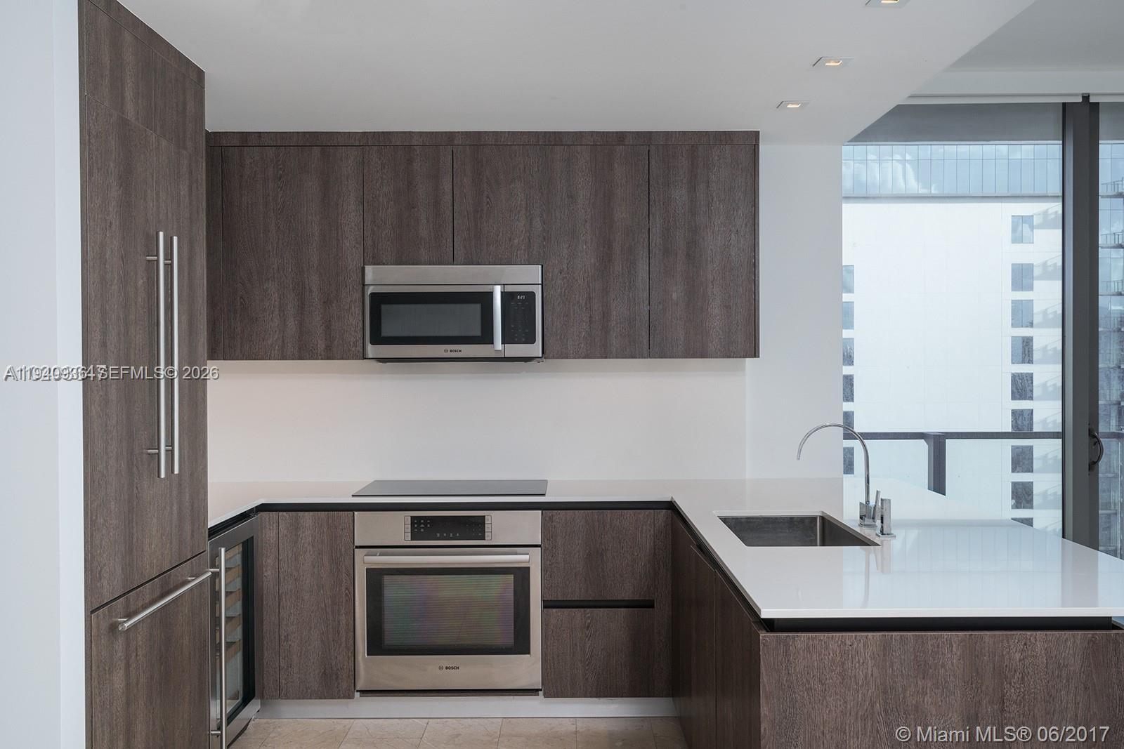 68 Southeast 6th Street, Unit 3402 Miami, FL 33131 - Photo 4 of 22 a kitchen with a sink stove and microwave