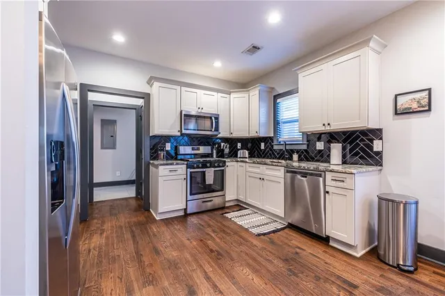 a kitchen with granite countertop white cabinets and white appliances