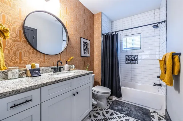 a bathroom with a granite countertop toilet sink and mirror