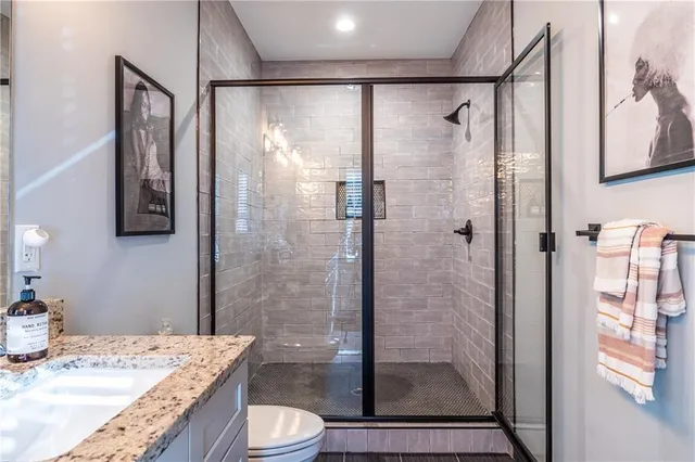 a bathroom with a granite countertop shower sink and toilet