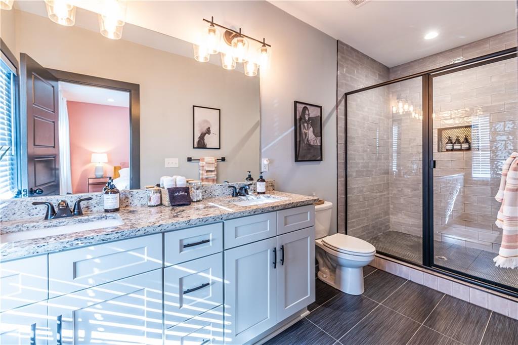 988 Mayson Turner Road Northwest Atlanta, GA 30314 - Photo 27 of 45 a bathroom with a granite countertop sink toilet a large mirror a shower and vanity