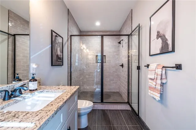 a bathroom with a granite countertop sink toilet and shower