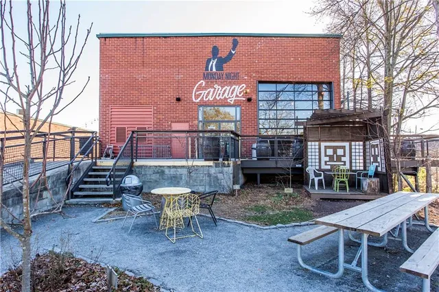 a backyard of a house with barbeque oven table and chairs