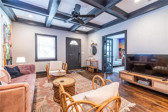 a living room with furniture a flat screen tv and kitchen view