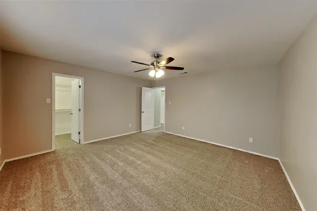 a view of an empty room with a ceiling fan