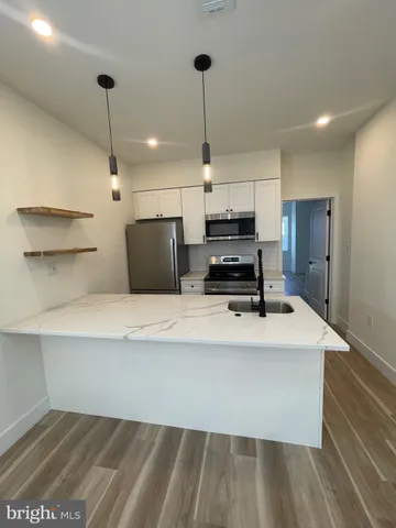 a kitchen with kitchen island white cabinets and refrigerator