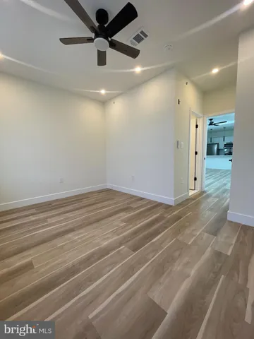 a view of empty room with wooden floor