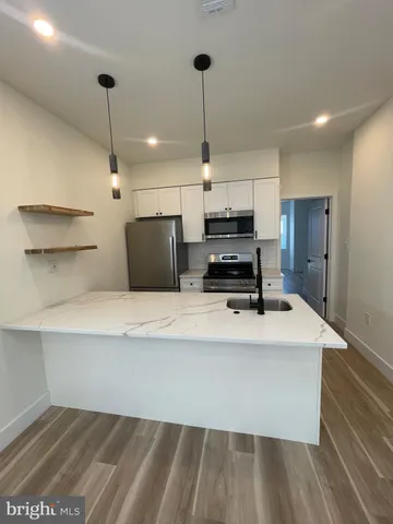 a kitchen with kitchen island white cabinets and refrigerator