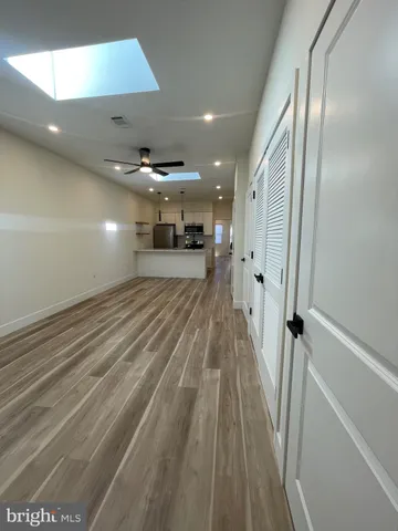 en empty room with wooden floor and a large window