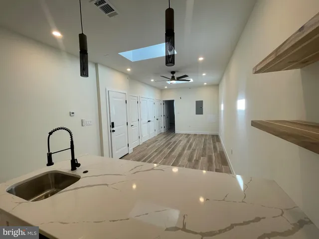 a kitchen with kitchen island sink stove and refrigerator