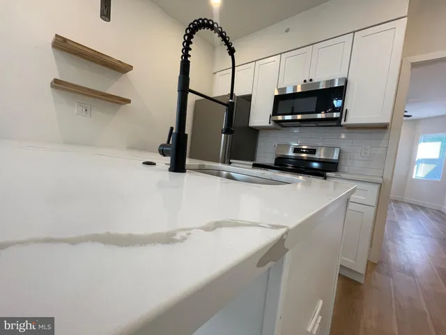 a kitchen with kitchen island a sink stainless steel appliances and cabinets