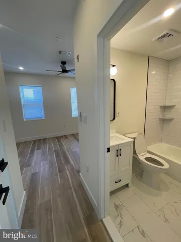 a bathroom with a sink a toilet a window and mirror