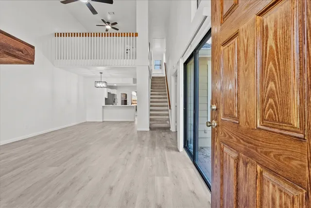 a view of a hallway with wooden floor and staircase