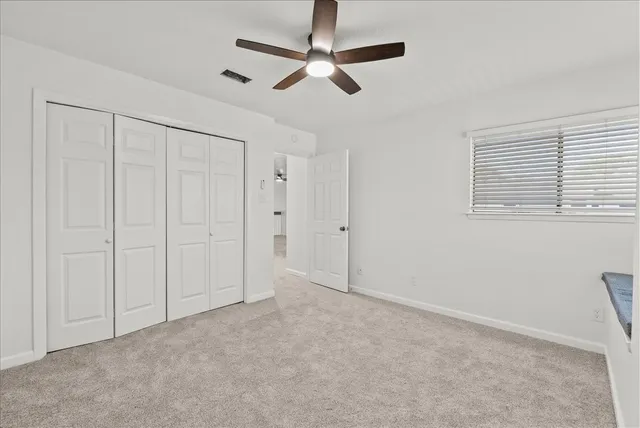 a view of an empty room and a ceiling fan