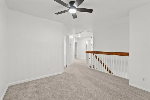 a view of a hallway with a ceiling fan