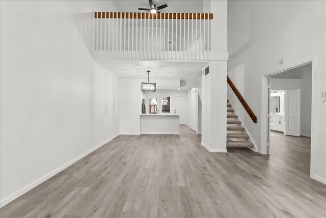 a view of a hallway with wooden floor and staircase