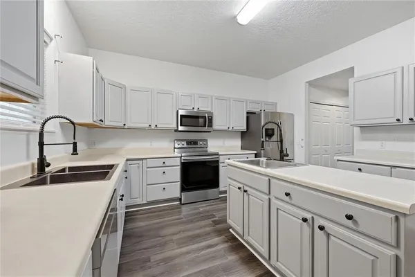 a kitchen with white cabinets stainless steel appliances and sink