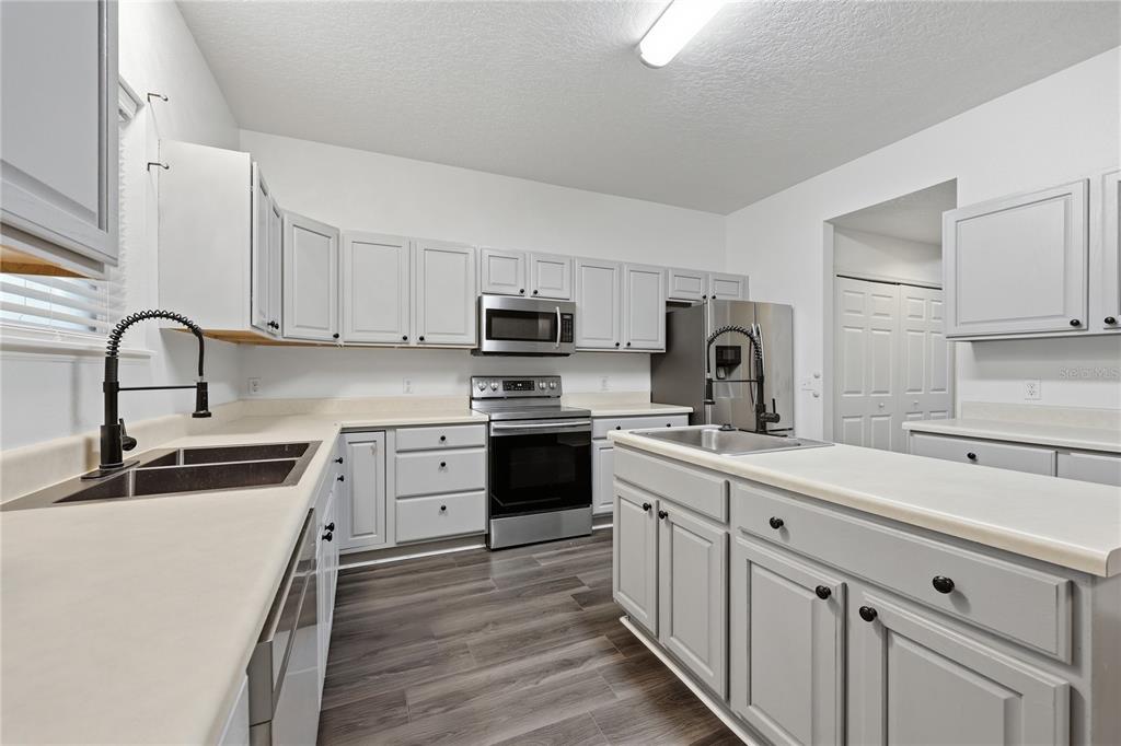 1348 Southwest 245th Way Newberry, FL 32669 - Photo 11 of 38 a kitchen with white cabinets stainless steel appliances and sink