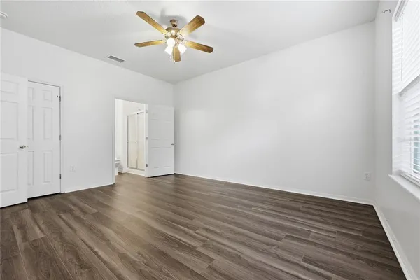 an empty room with wooden floor and window