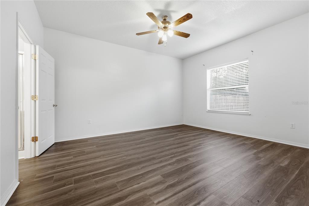 1348 Southwest 245th Way Newberry, FL 32669 - Photo 15 of 38 an empty room with wooden floor and windows