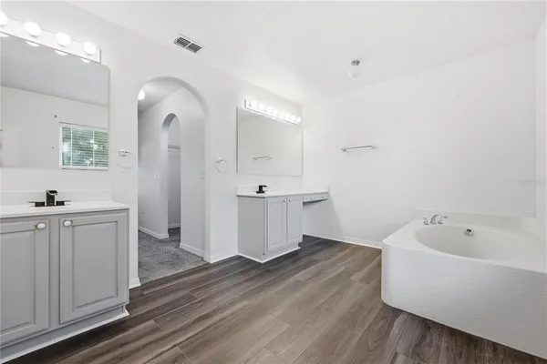 a view of a bathroom with tub sink and mirror