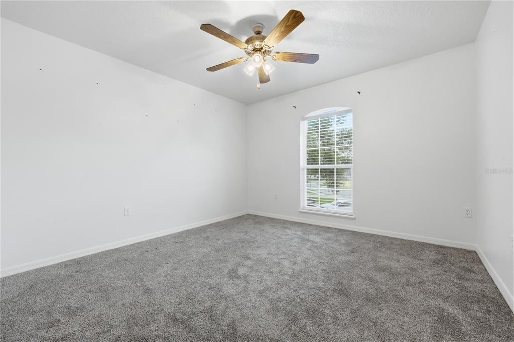 1348 Southwest 245th Way Newberry, FL 32669 - Photo 25 of 38 an empty room with windows and ceiling fan