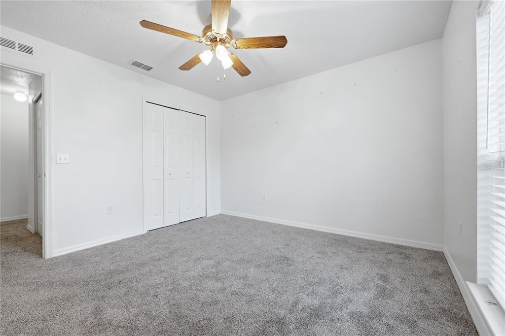 1348 Southwest 245th Way Newberry, FL 32669 - Photo 31 of 38 an empty room with a chandelier fan and windows
