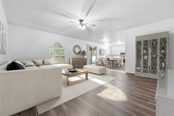 a living room with furniture and view of kitchen