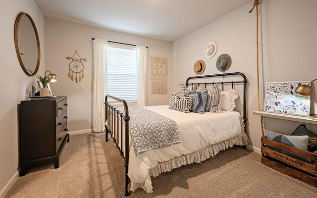 a bedroom with a bed and dresser with mirror