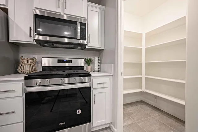 a kitchen with stainless steel appliances a stove microwave and cabinets