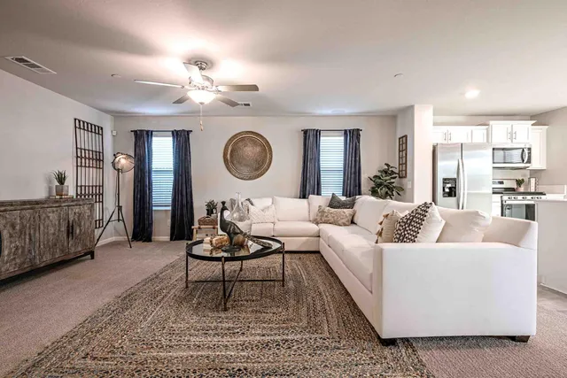 a living room with furniture a clock on wall and a large window