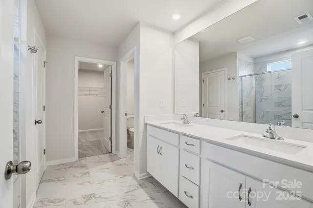 a spacious bathroom with double sink and a mirror