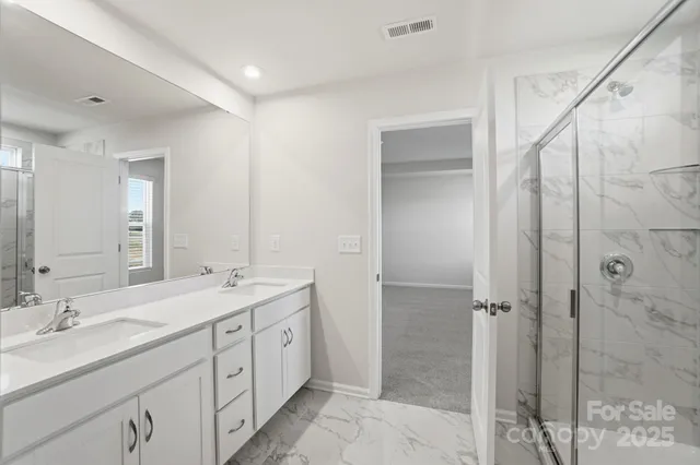 a spacious bathroom with a double vanity sink mirror and shower