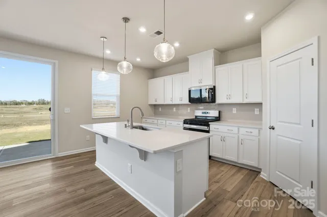 a kitchen with a sink stove and microwave