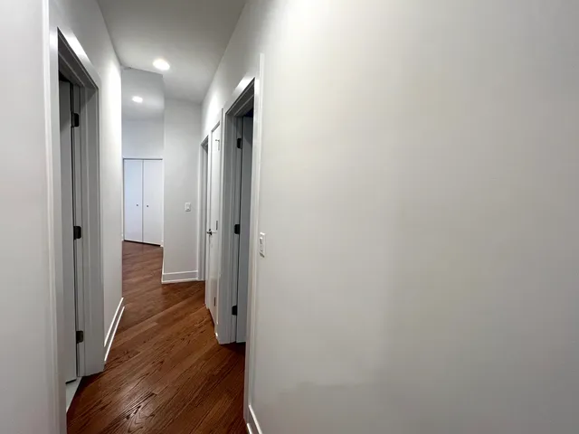 a view of a hallway with wooden floor and staircase