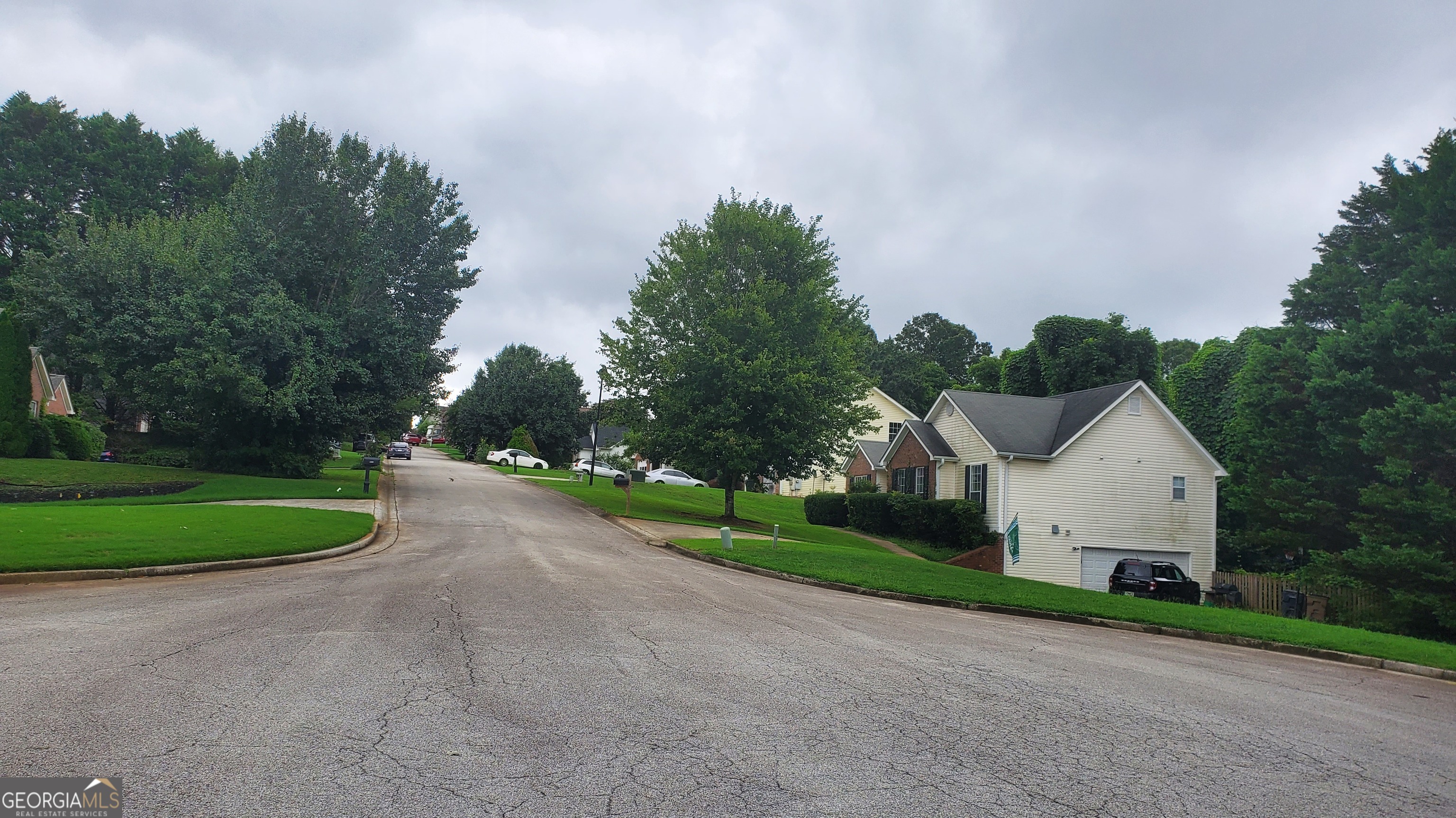 5536 Rolling Mist Court Flowery Branch, GA 30542 - Photo 2 of 3 a view of a house with a yard and large trees