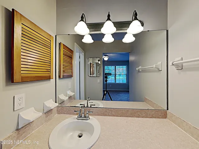 a bathroom with a sink mirror and vanity