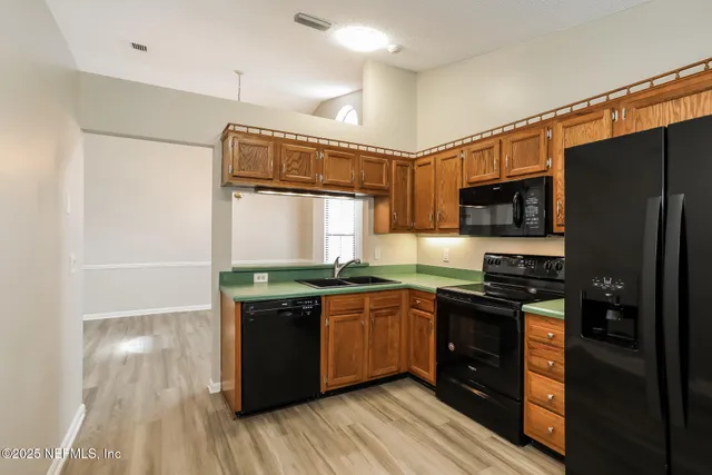 a kitchen with stainless steel appliances granite countertop a stove a sink and a refrigerator
