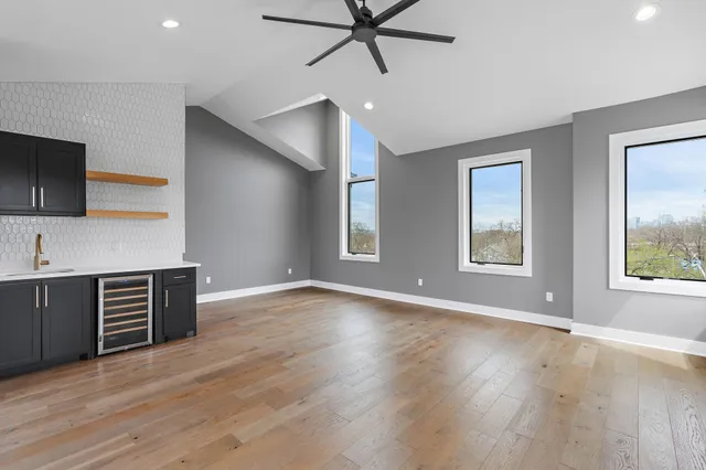 a view of an empty room with window and wooden floor