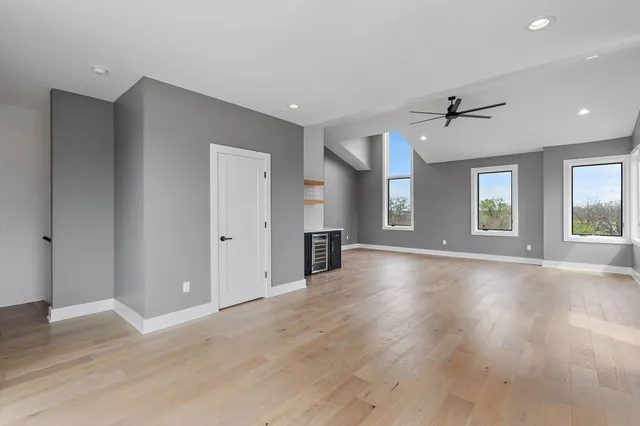 a view of an empty room with window and wooden floor
