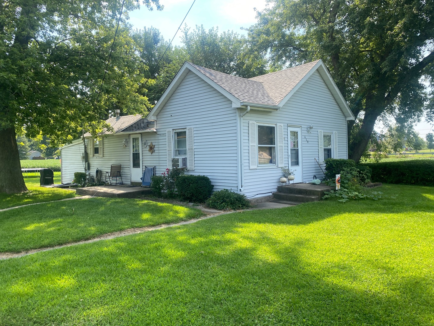 a view of a house with a yard and chairs