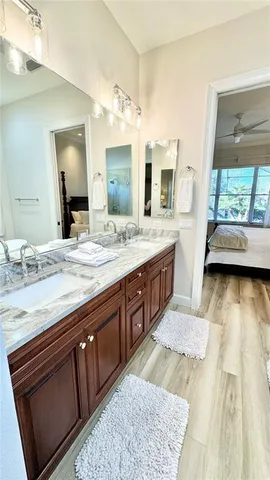 a spacious bathroom with a granite countertop sink a mirror and a bathtub