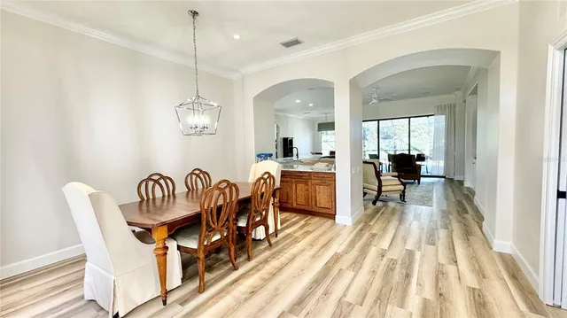 a view of a dining room with furniture a rug and wooden floor
