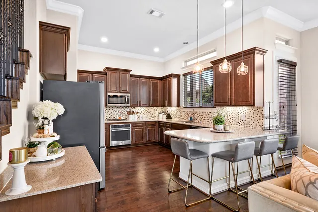 a kitchen with stainless steel appliances kitchen island granite countertop a stove a sink and a refrigerator